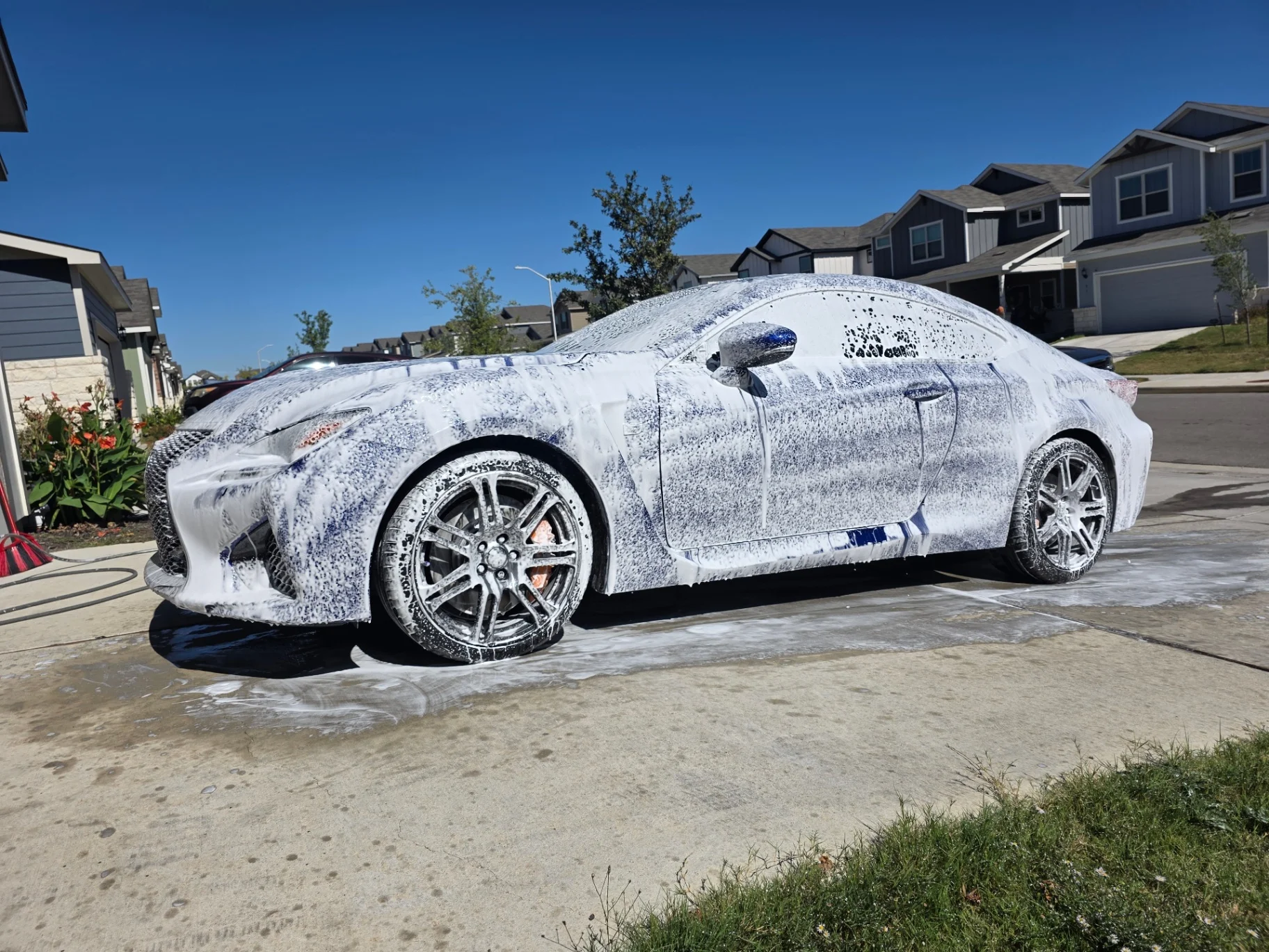 Blue Lexus RC F covered in thick foam during a foam-cannon wash