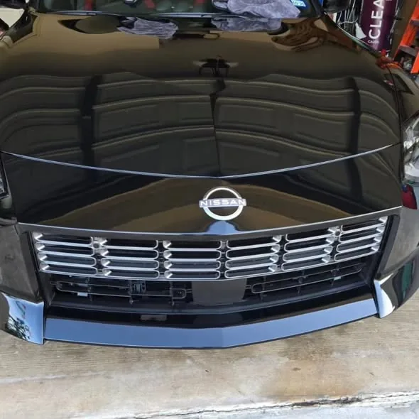 Mirror-like reflection on a black Nissan 350Z hood after detail