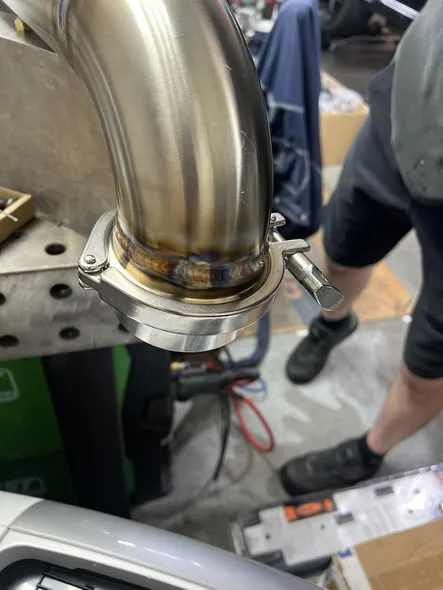 Close-up of TIG-welded V-band flange on a custom exhaust